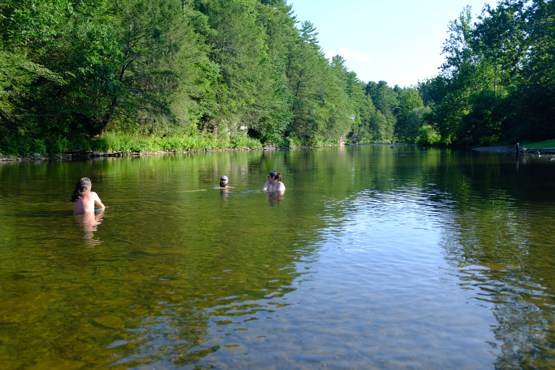 Riders cooling off with a swim in a calm river after a day of riding