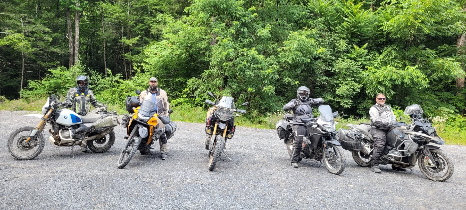 The five riders lined up on their bikes on a gravel pull-off on the final day