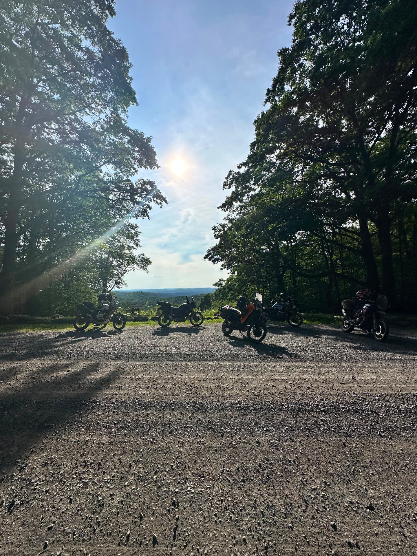 Five adventure bikes parked at a mountaintop overlook in late afternoon sun