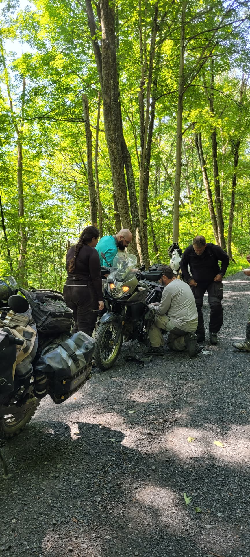 The group gathered around a bike on the trail troubleshooting an electrical fault