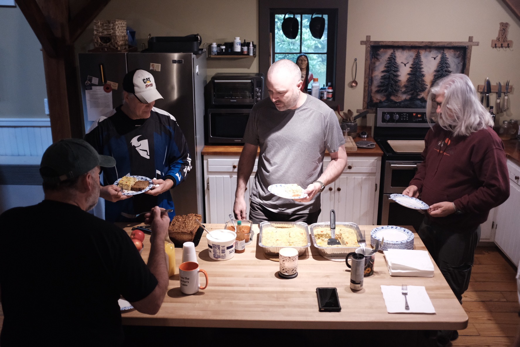 Riders gathered with breakfast plates around the kitchen island