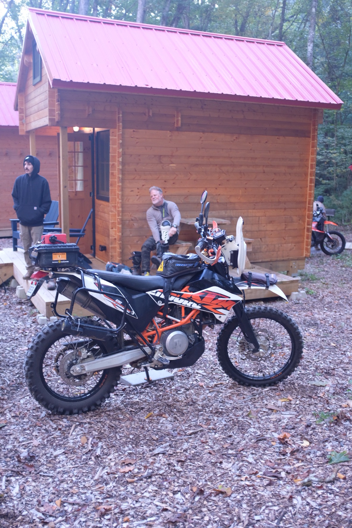 KTM adventure motorcycle and rider beside the cabins