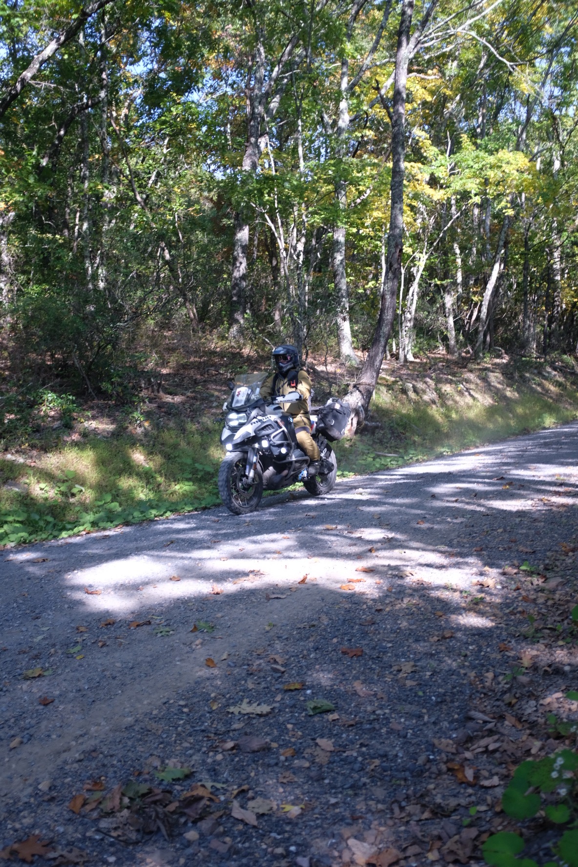 Adventure rider traveling a gravel road through the Virginia woods