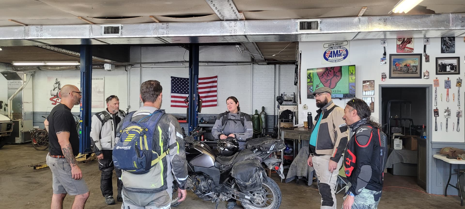 Riders talking with the mechanic inside a small motorcycle shop in Renovo, PA