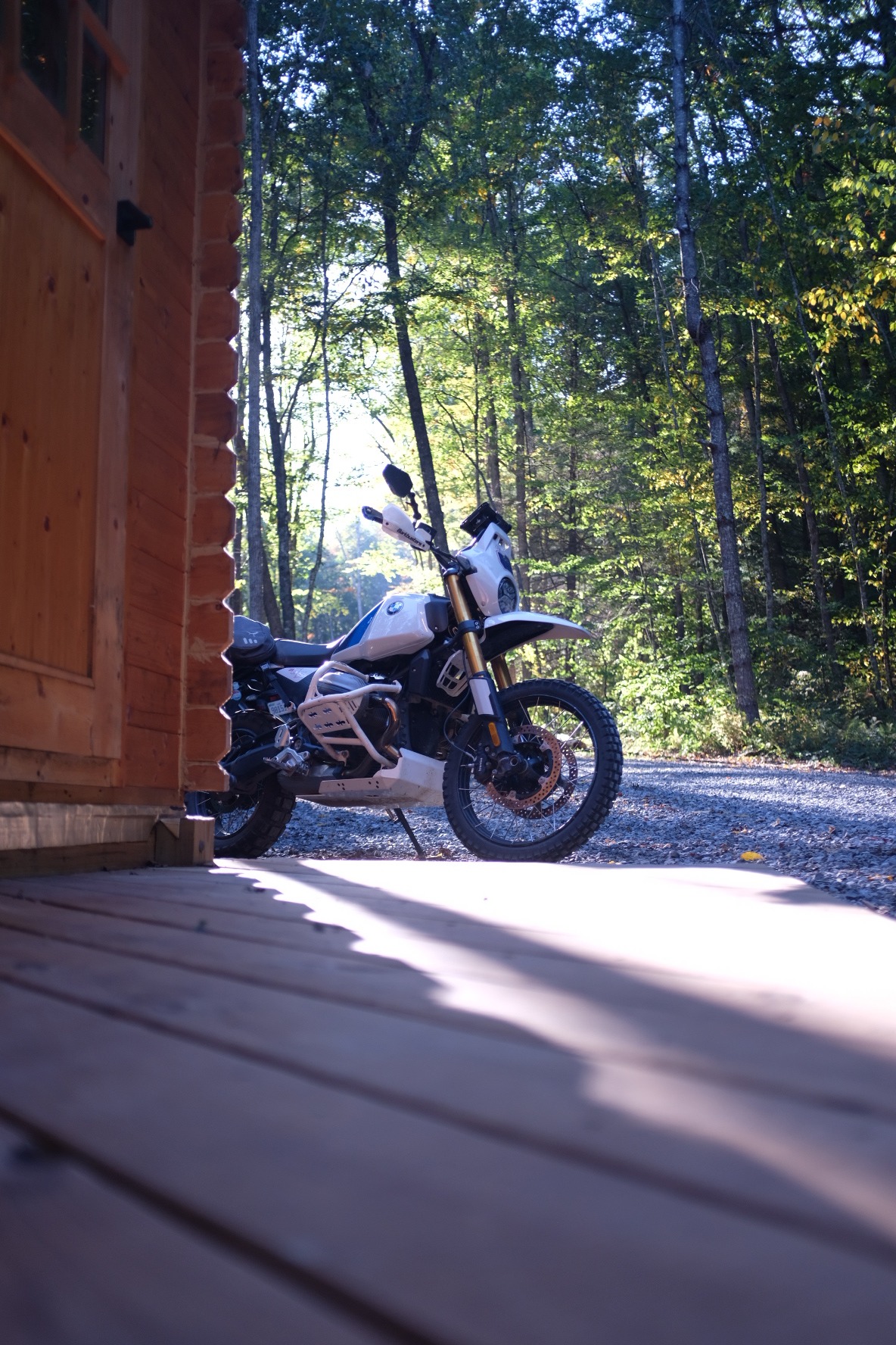 BMW adventure motorcycle parked beside a cabin porch